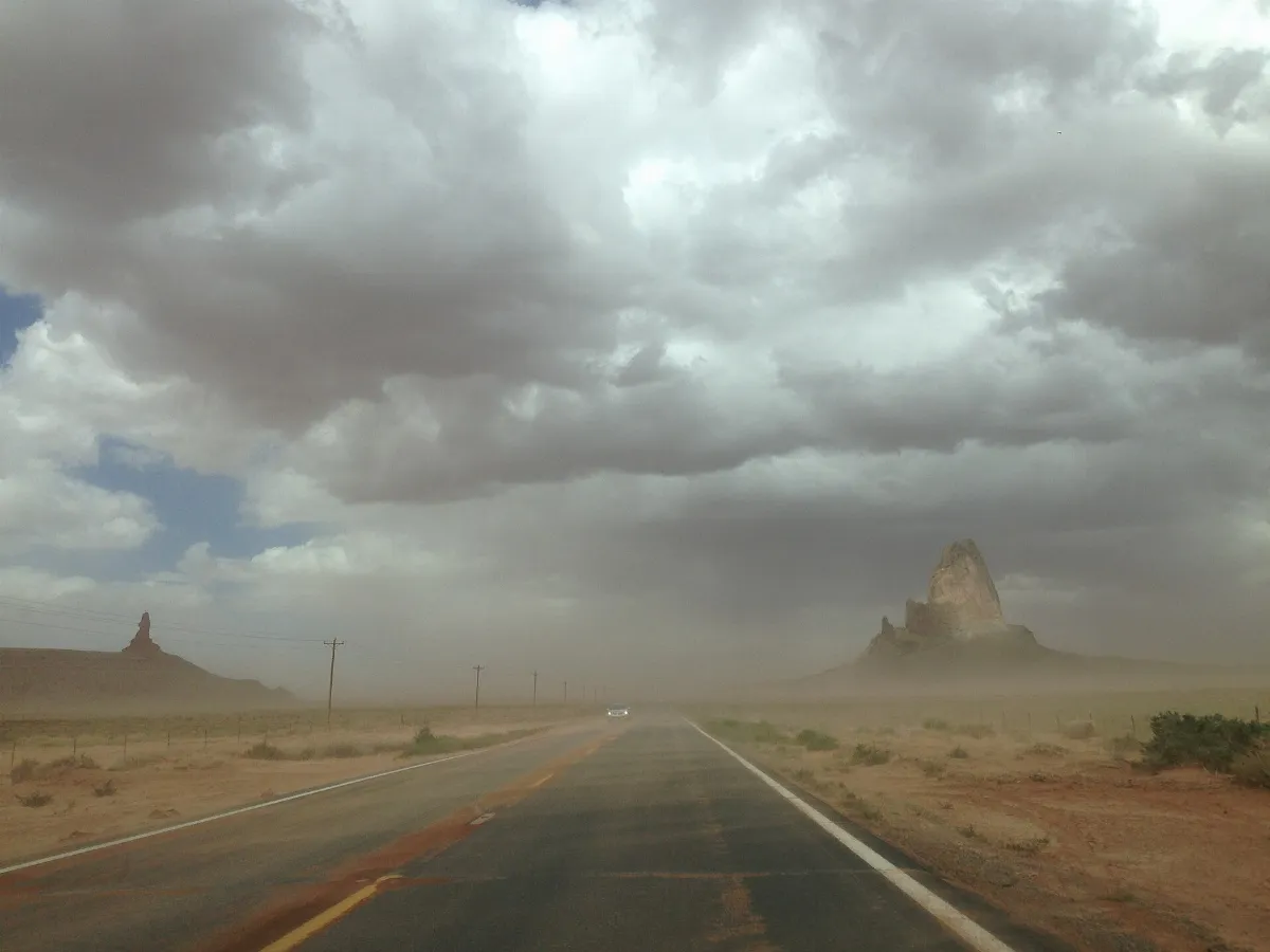 2013-09-22 13 27 44 View north along U.S. Route 163 towards Agathla Peak and Owl Rock with dust and sand blowing across the highway